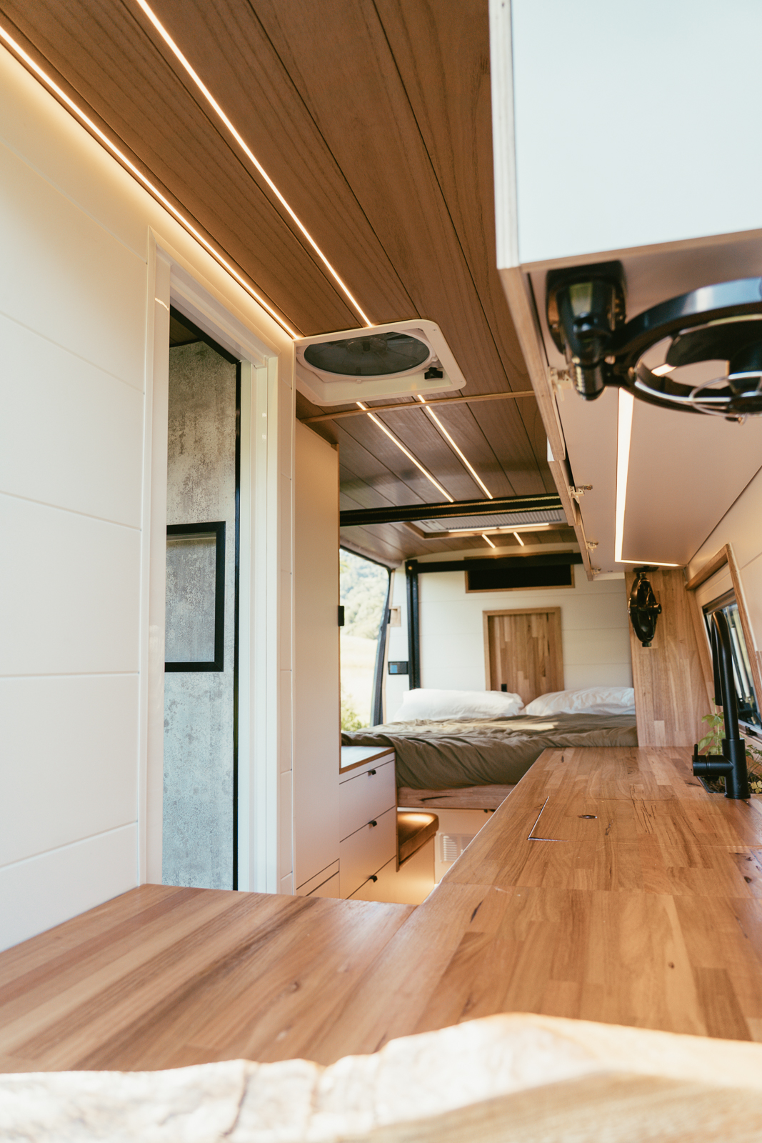 Sprinter camper interior looking through to the bed and bathroom door