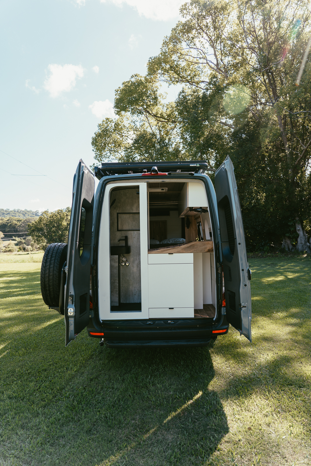 2025 AWD Sprinter with rear doors open showing bathroom and kitchen